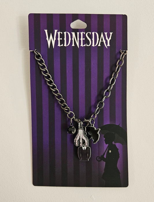 Wednesday Necklace with a hand holding an umbrella charm on a 'Wednesday' branded card.