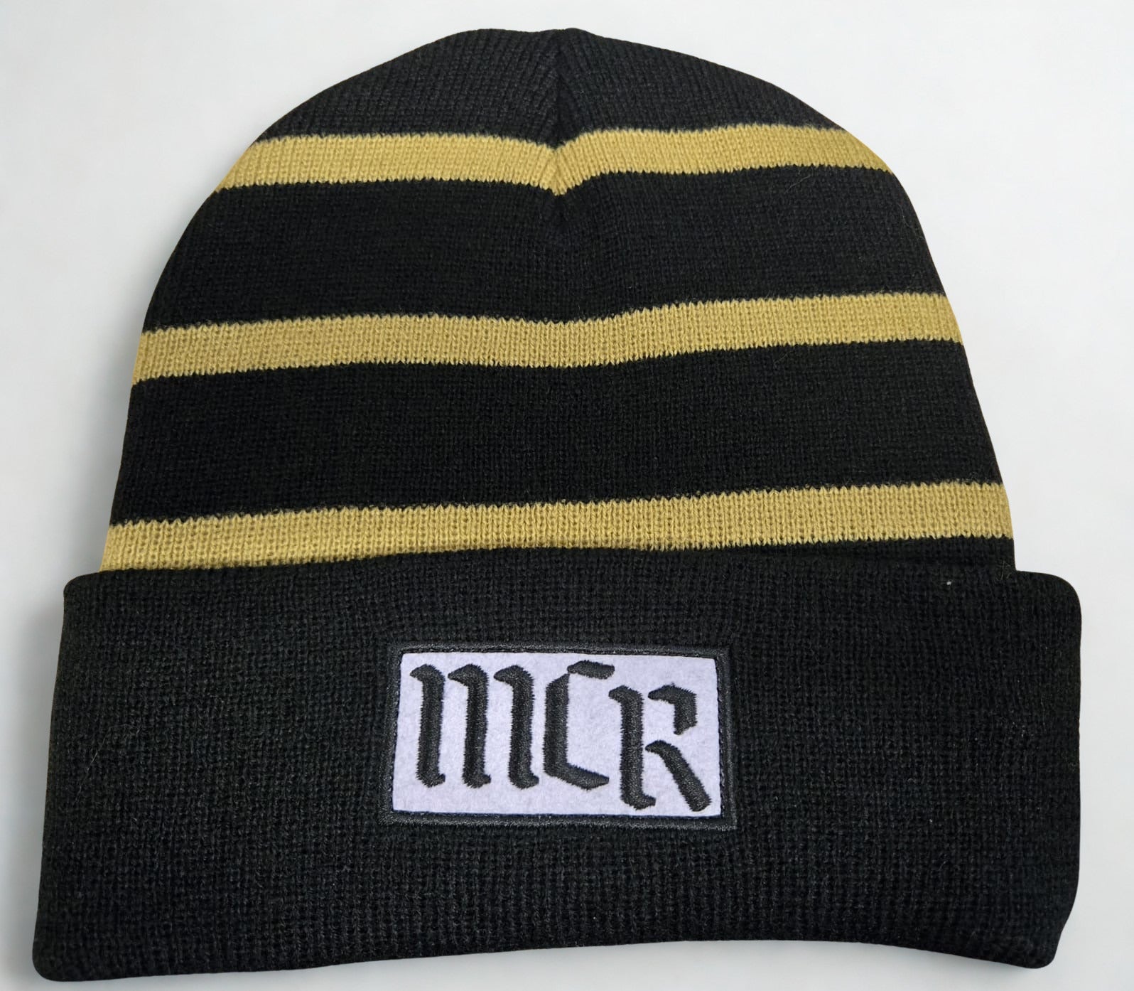Black beanie with gold stripes and 'MCR' logo on a white background