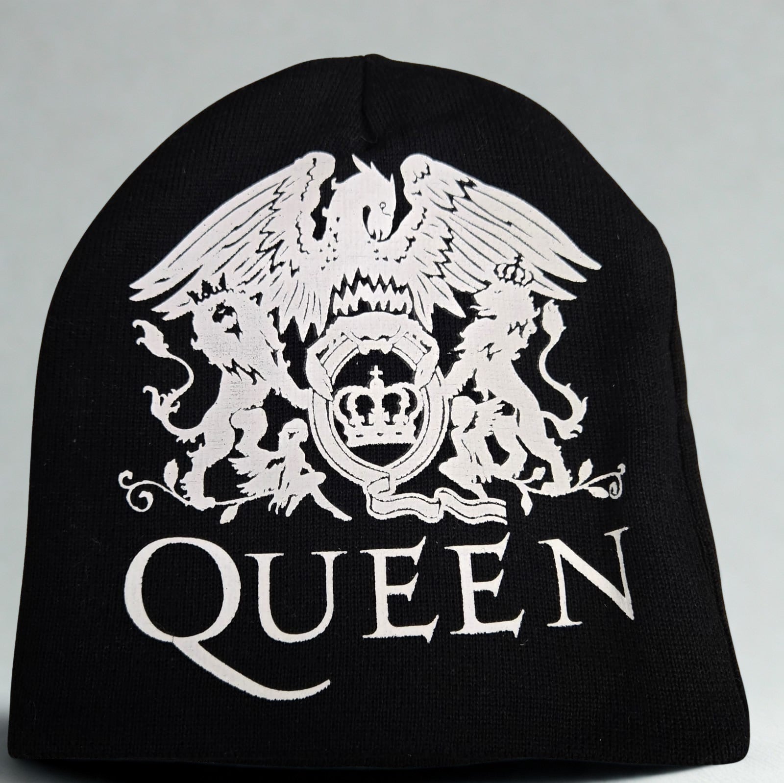 Black beanie with white 'Queen' logo on a gray background