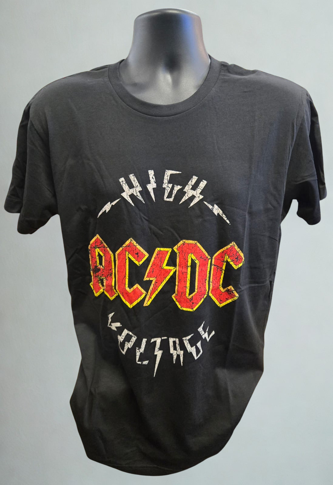 Black t-shirt with AC/DC logo on a mannequin against a gray background