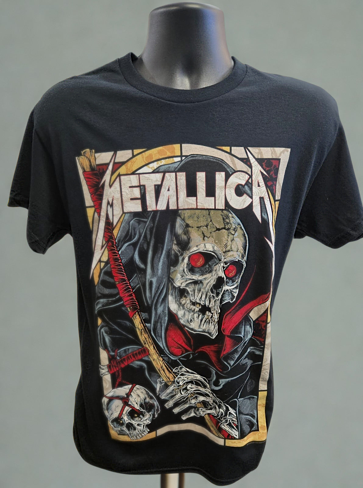 Black t-shirt with Metallica graphic design on a mannequin against a gray background