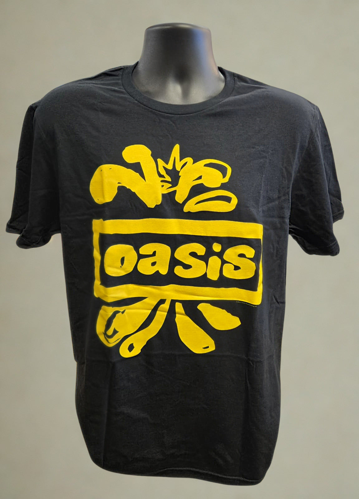 Black t-shirt with yellow 'oasis' logo on a mannequin against a plain background